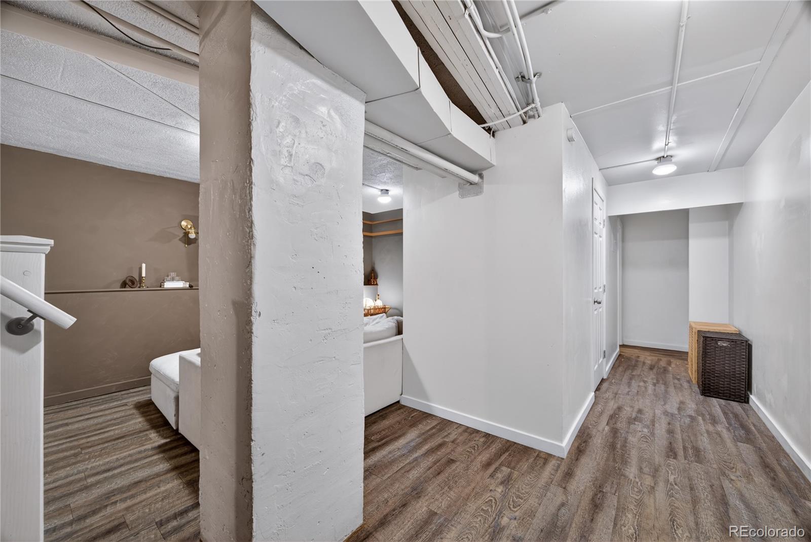6730 Oneida Street Commerce City, CO 80022 - Photo 24 of 37 a view of a hallway with wooden floor and a bathroom