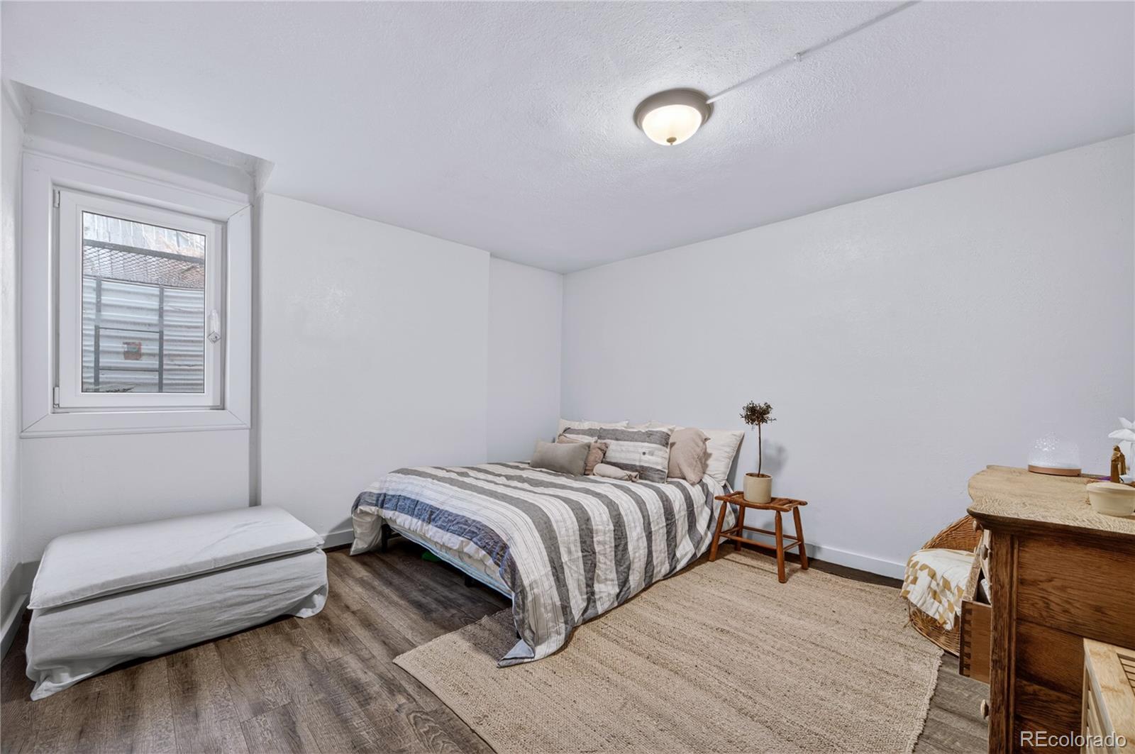 6730 Oneida Street Commerce City, CO 80022 - Photo 26 of 37 a bedroom with a bed and a chair