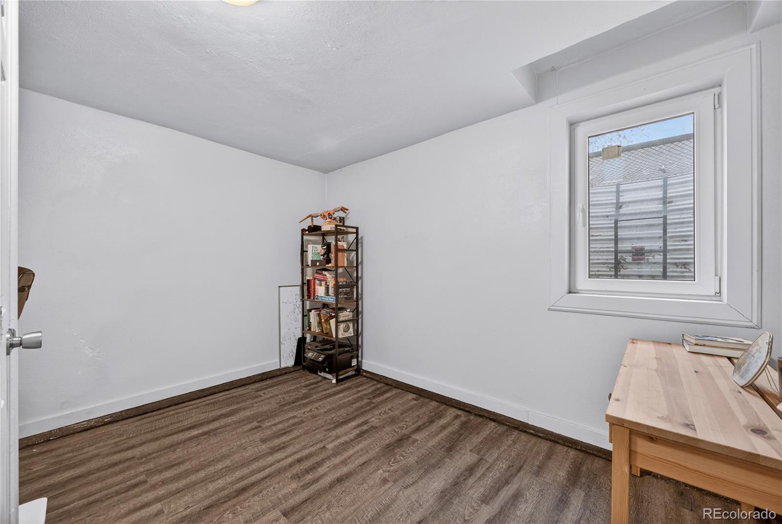 6730 Oneida Street Commerce City, CO 80022 - Photo 28 of 37 an empty room with wooden floor and windows