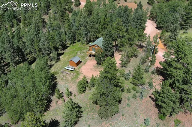 an aerial view of residential house with outdoor space and trees all around