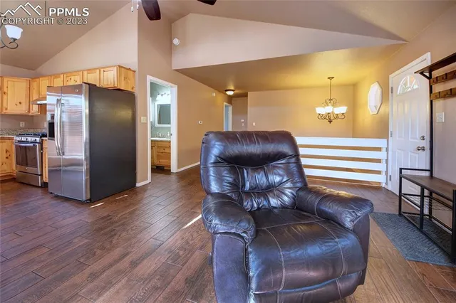 a kitchen with stainless steel appliances kitchen island granite countertop a table chairs and a refrigerator
