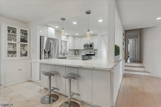 a kitchen with kitchen island a appliances a sink and cabinets