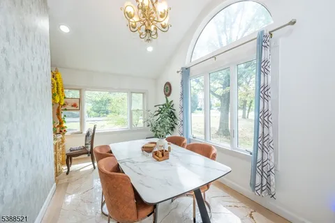 a view of a dining room with furniture a chandelier and wooden floor