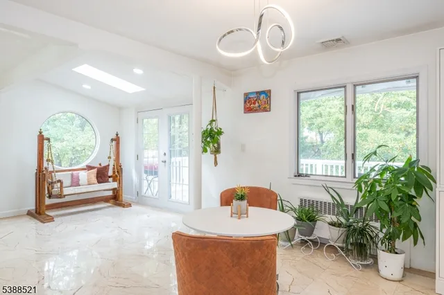 a living room with furniture potted plant and a large window