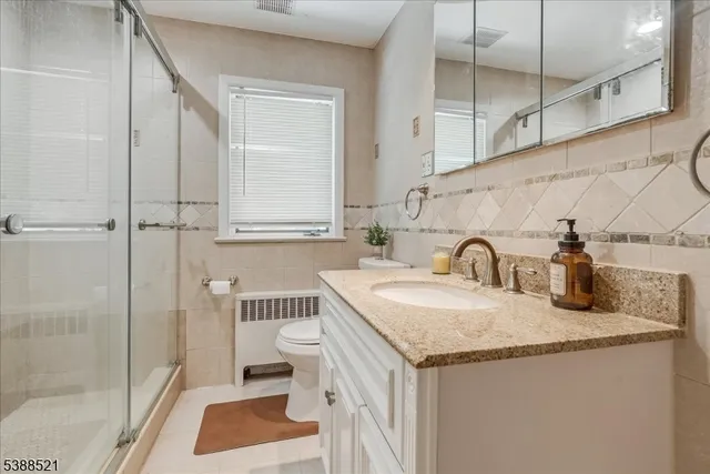 a bathroom with a granite countertop sink a toilet and a shower