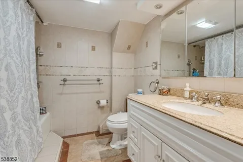 a spacious bathroom with a granite countertop sink a toilet and a mirror