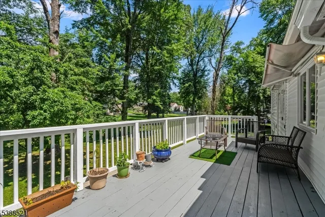a view of a deck with two chair and wooden floor