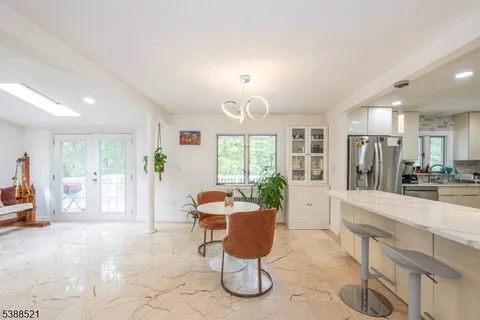 a large living room with stainless steel appliances furniture a rug and a view of kitchen