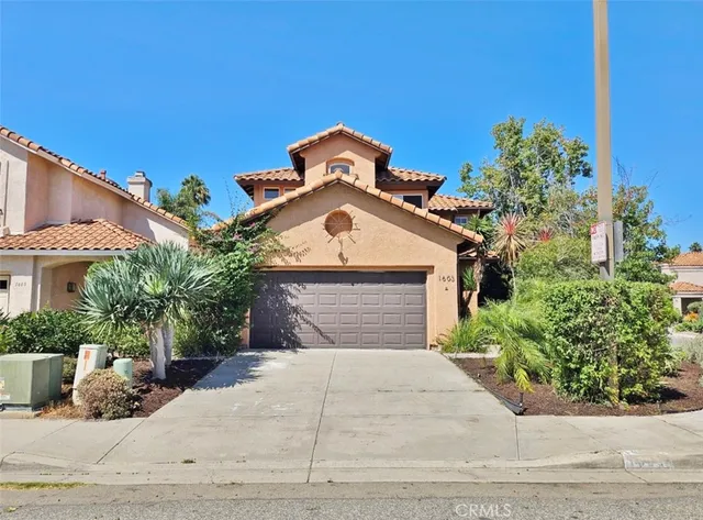 a front view of a house with a yard and a garage