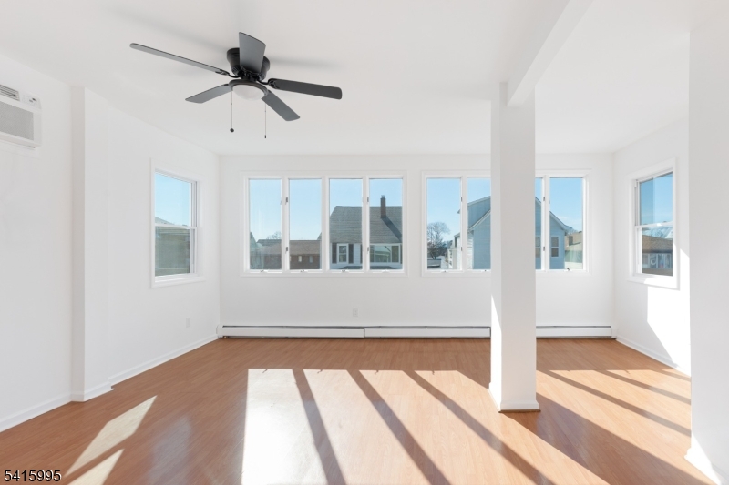 118 Ray Street Garfield, NJ 07026 - Photo 2 of 15 a view of an empty room with wooden floor and a window
