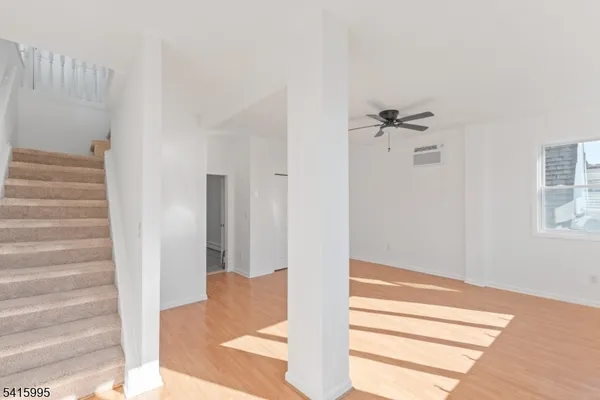 a view of a hallway with wooden floor and staircase