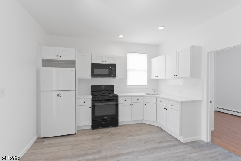 118 Ray Street Garfield, NJ 07026 - Photo 7 of 15 a kitchen with granite countertop a refrigerator stove and sink