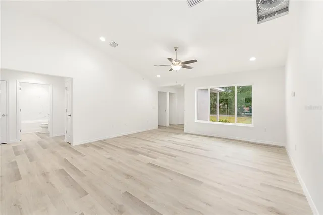 a view of a big room with wooden floor closet and windows