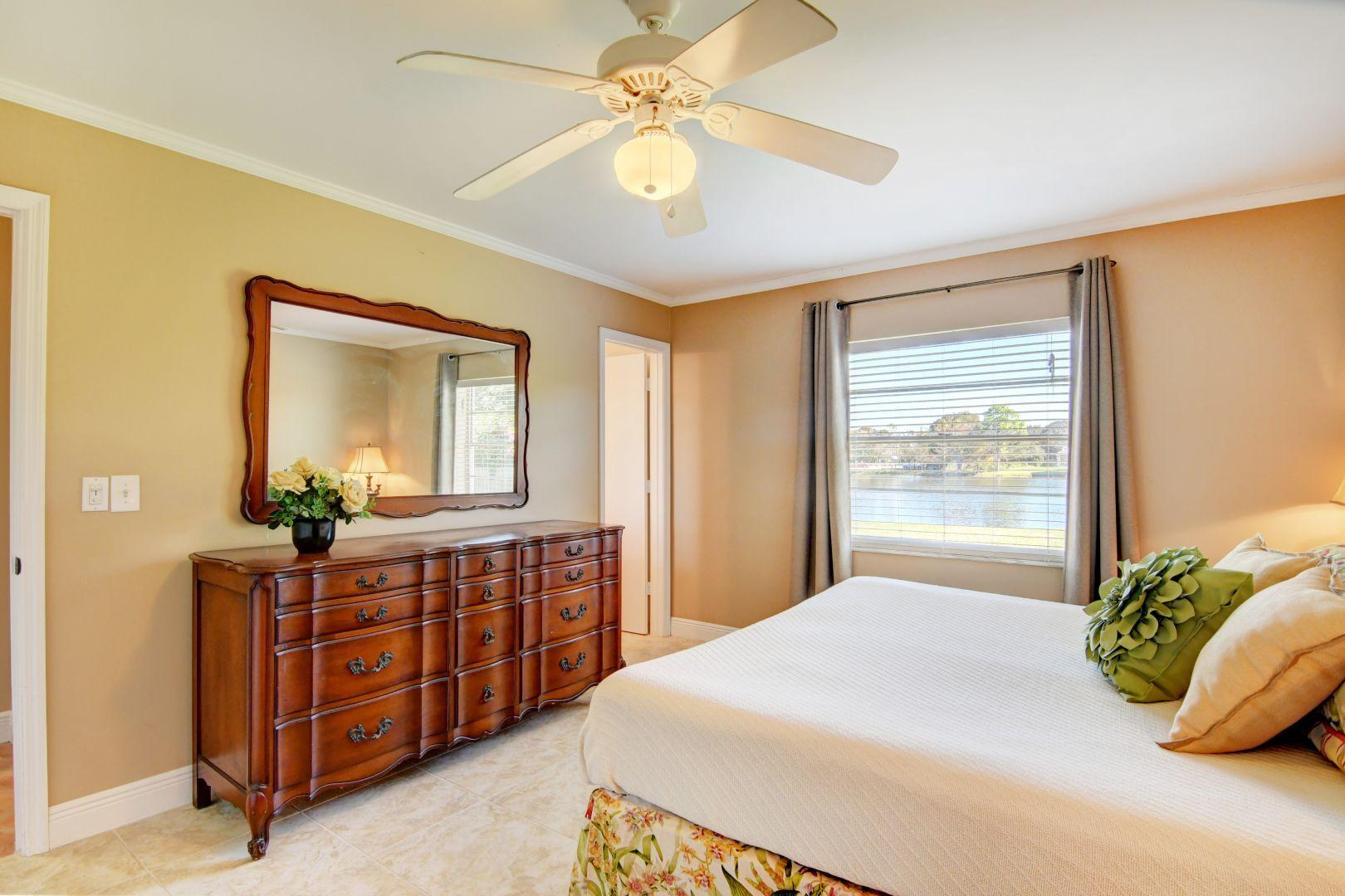 9989 Liberty Road Boca Raton, FL 33434 - Photo 13 of 44 a bedroom with a bed and a chandelier