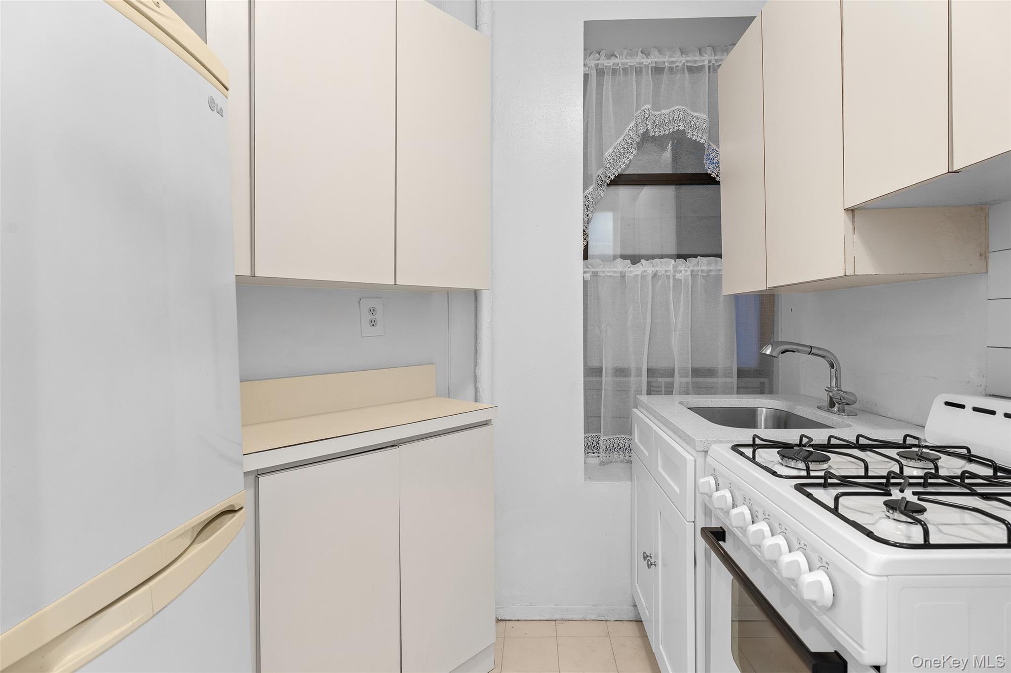 246 East 51st Street, Unit 7 Manhattan, NY 10022 - Photo 5 of 9 a kitchen with stainless steel appliances granite countertop a stove and a refrigerator