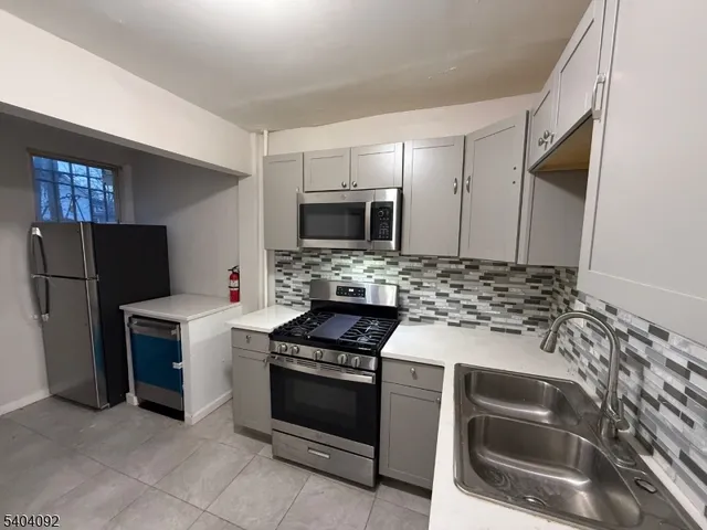 a kitchen with granite countertop a stove and a refrigerator
