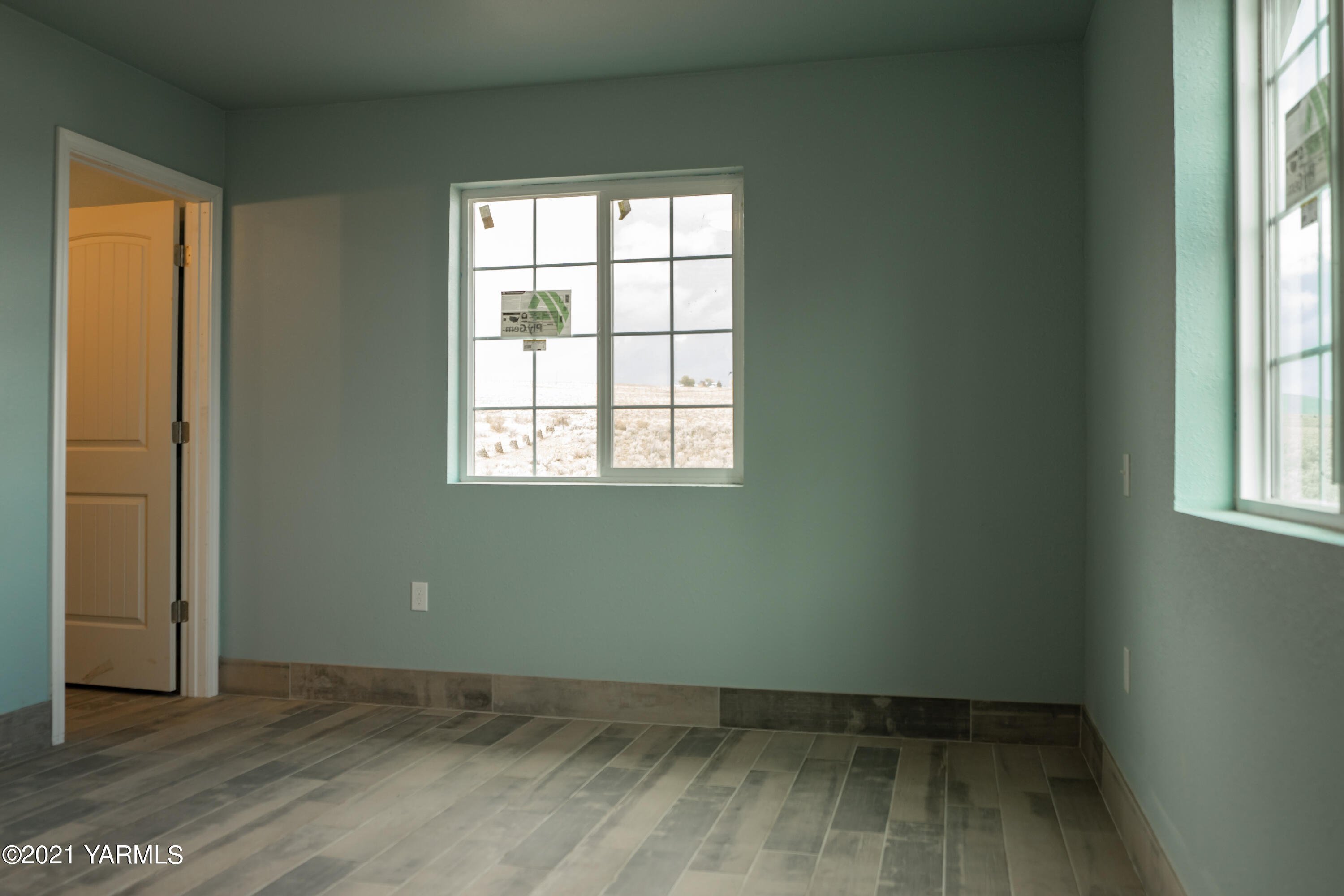 281 Starview Road Yakima, WA 98908 - Photo 22 of 26 an empty room with wooden floor and windows