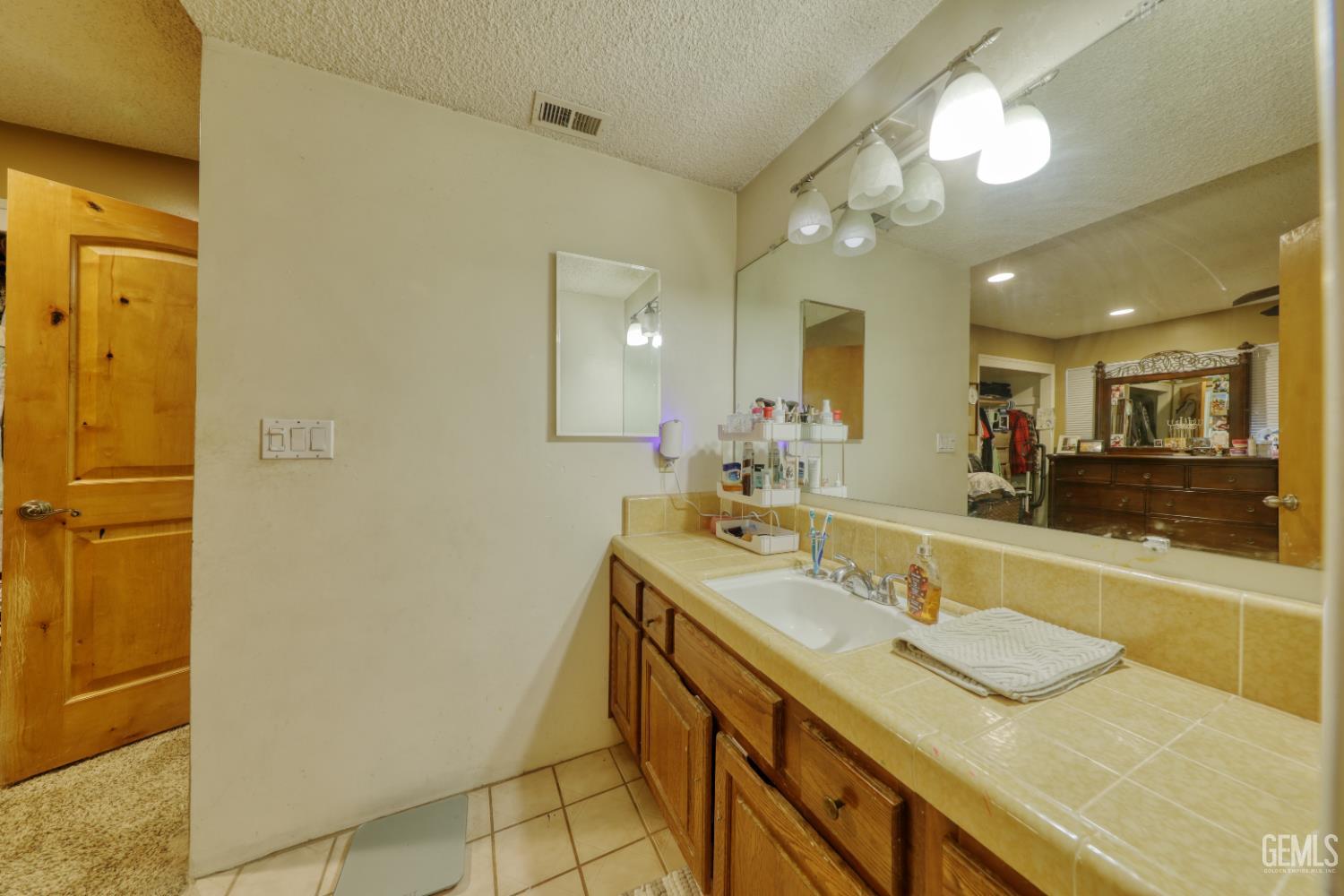 Undisclosed Address Bakersfield, CA 93308 - Photo 31 of 64 a bathroom with a granite countertop sink and a mirror