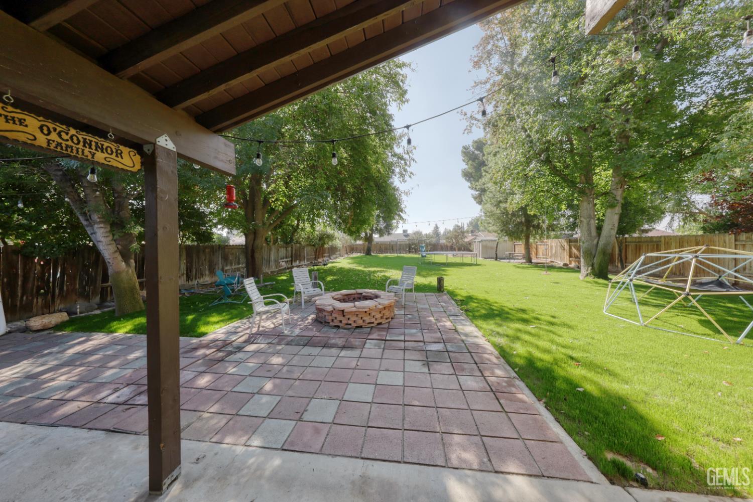 Undisclosed Address Bakersfield, CA 93308 - Photo 45 of 64 a view of a patio with table and chairs potted plants and a palm tree