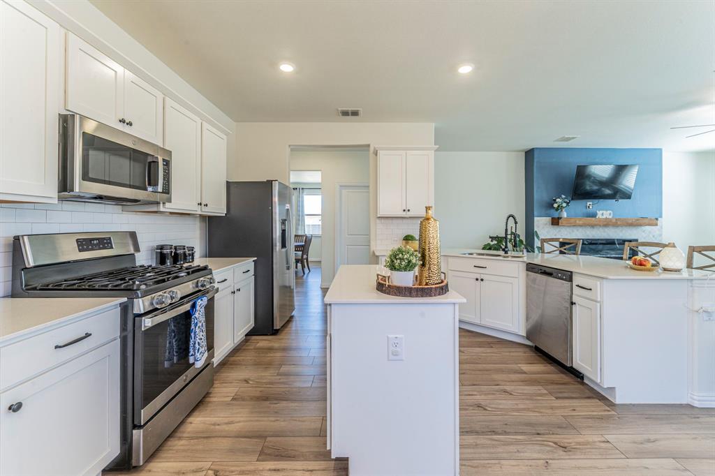 1240 Almond Road Azle, TX 76020 - Photo 6 of 26 a kitchen with stainless steel appliances granite countertop a stove top oven a sink dishwasher and a refrigerator with wooden floor