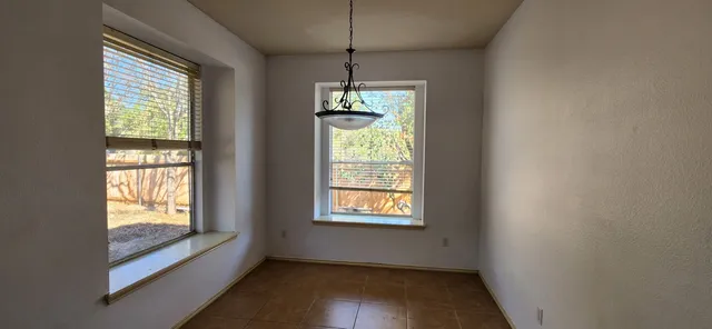 a kitchen with refrigerator a stove and white cabinets