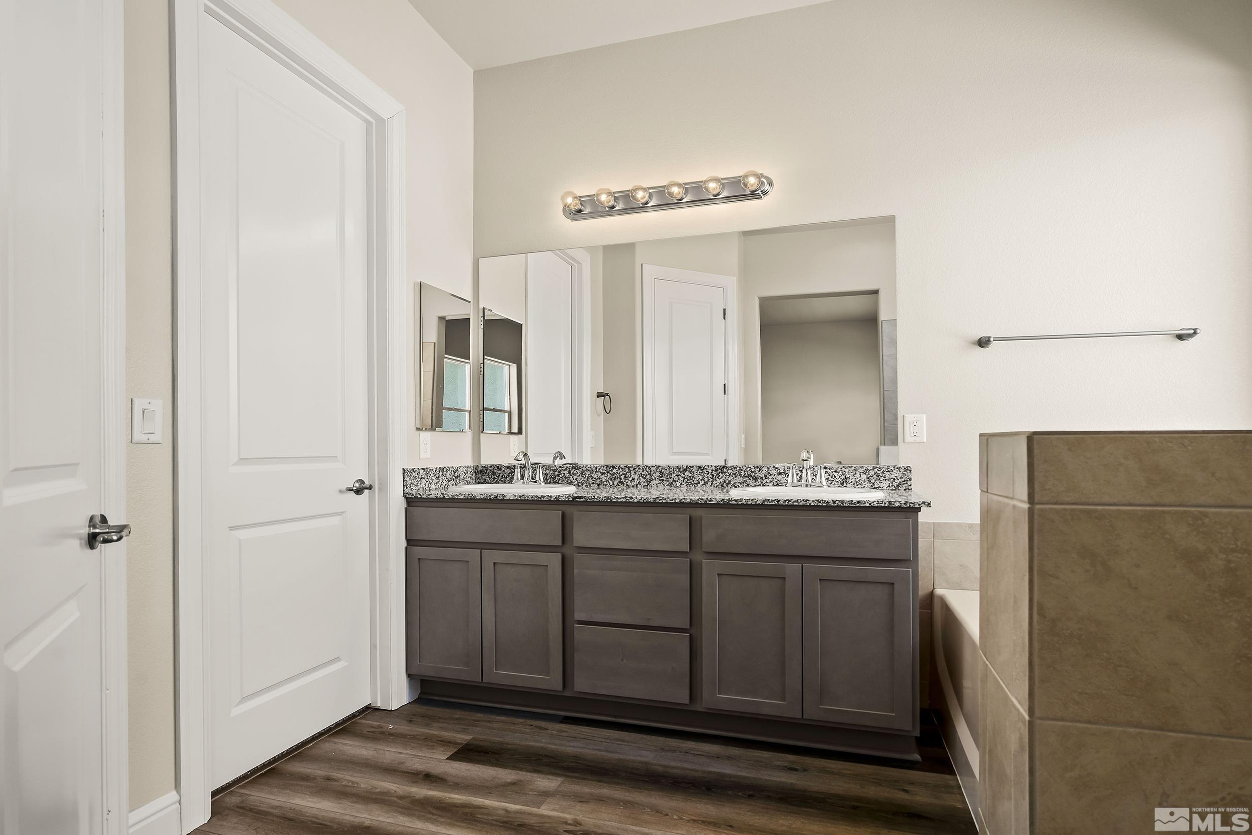 11048 Athabasca Drive Reno, NV 89506 - Photo 14 of 16 a bathroom with a granite countertop sink and a mirror