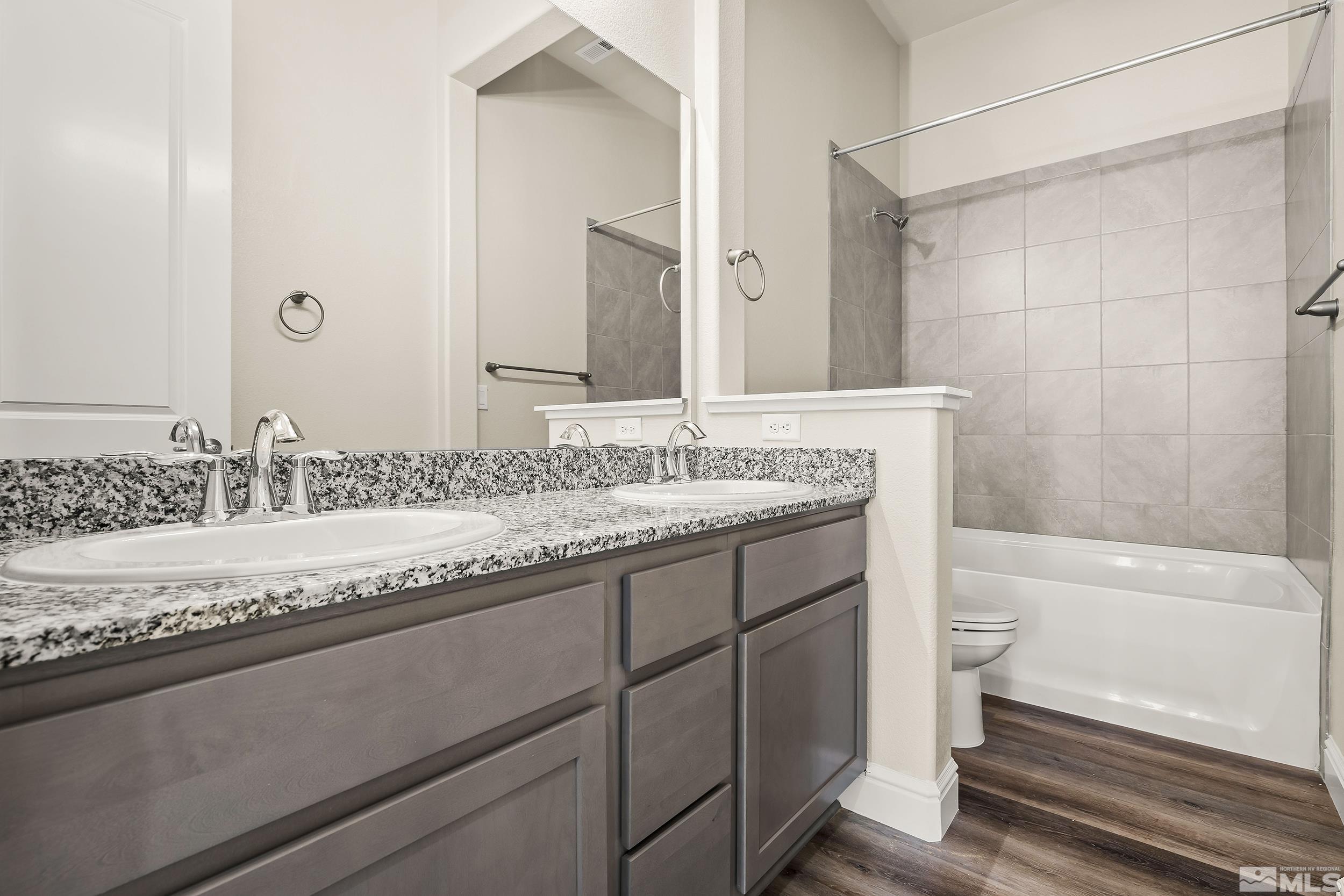11048 Athabasca Drive Reno, NV 89506 - Photo 2 of 16 a bathroom with a granite countertop bathtub sink vanity and toilet