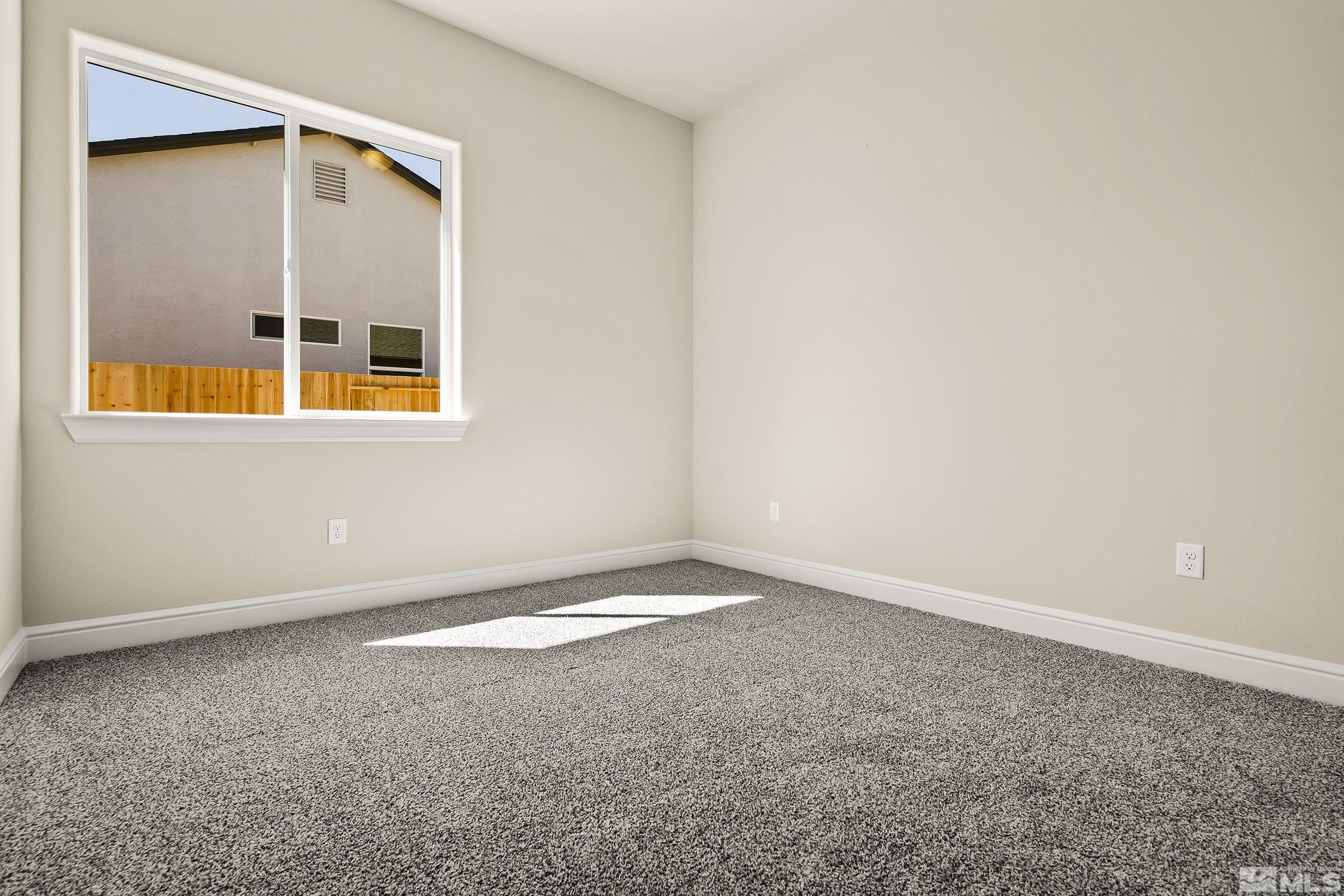 11048 Athabasca Drive Reno, NV 89506 - Photo 4 of 16 an empty room with wooden floor and windows