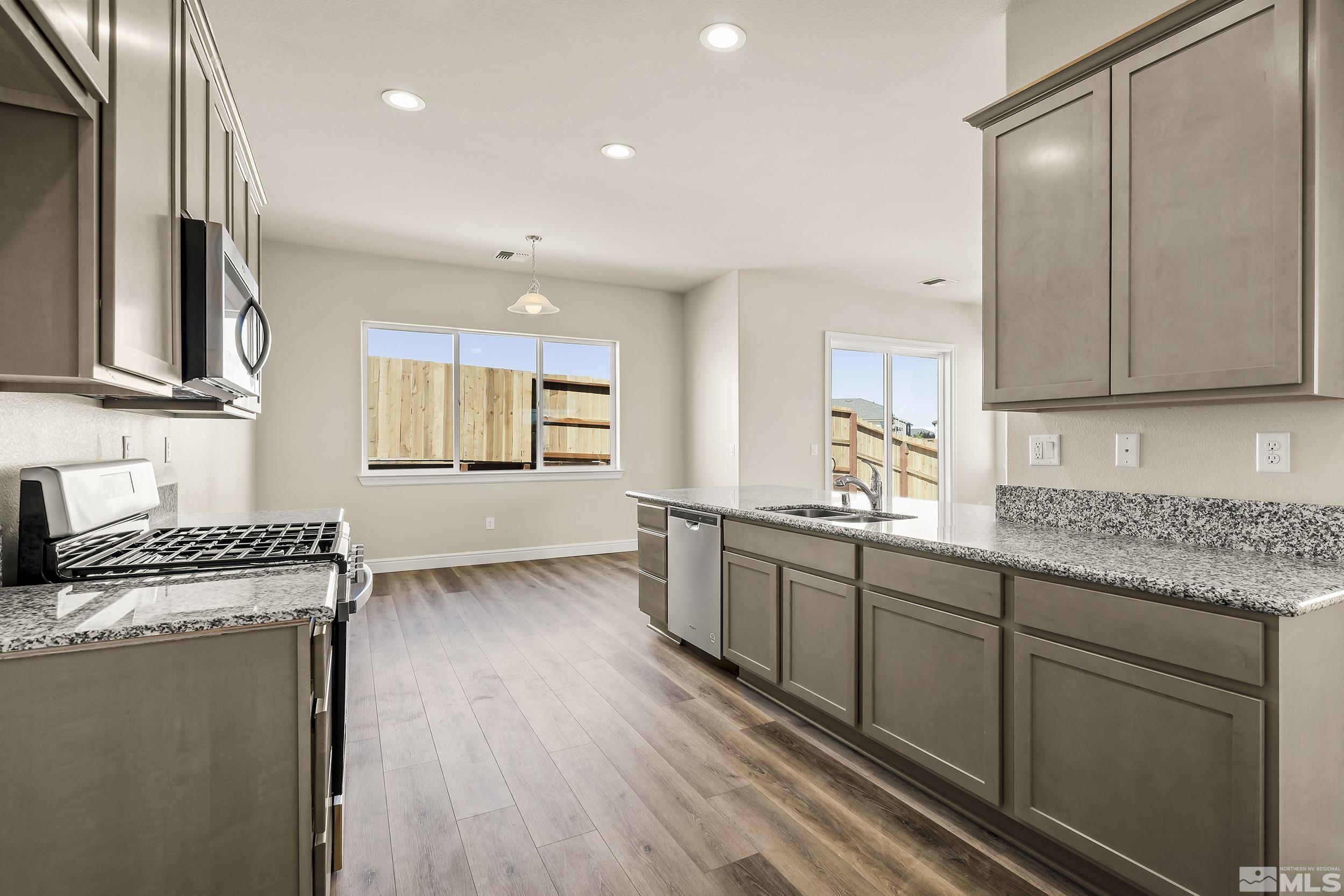 11048 Athabasca Drive Reno, NV 89506 - Photo 6 of 16 a kitchen with granite countertop cabinets stainless steel appliances a sink and a window