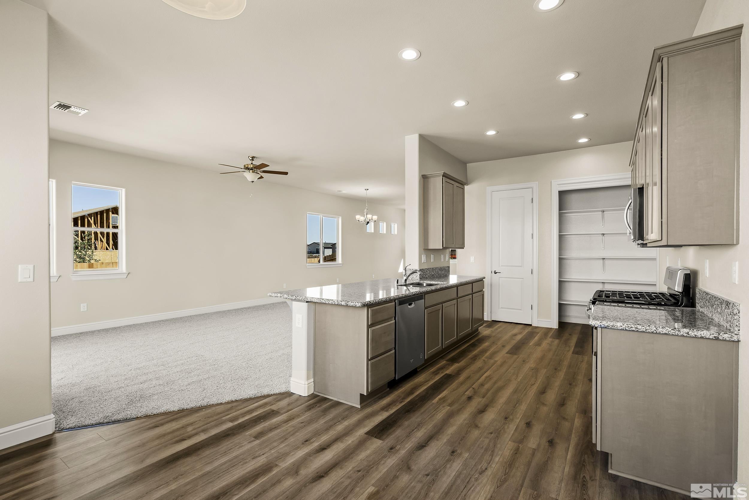 11048 Athabasca Drive Reno, NV 89506 - Photo 7 of 16 a large kitchen with stainless steel appliances granite countertop a stove a sink and a refrigerator