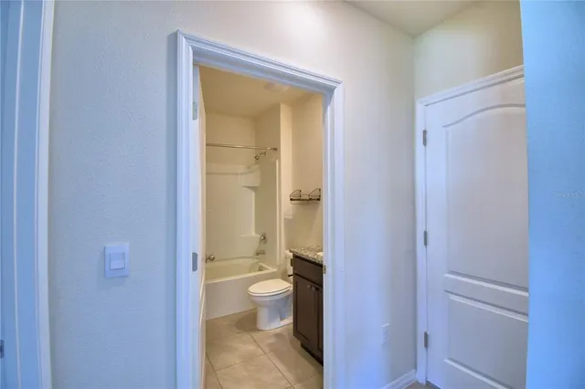 a bathroom with a granite countertop toilet and a sink