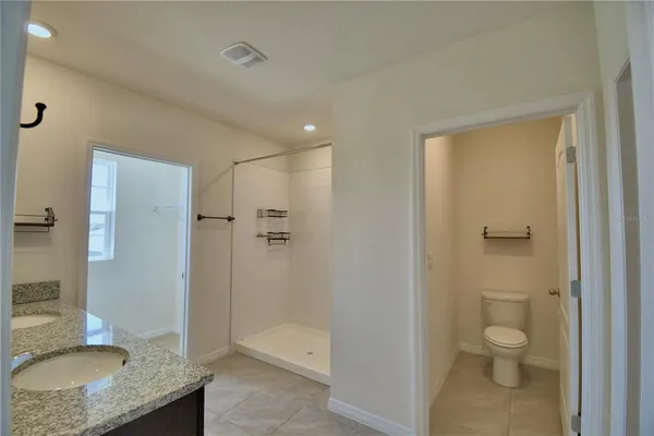 a bathroom with a granite countertop sink a toilet and shower