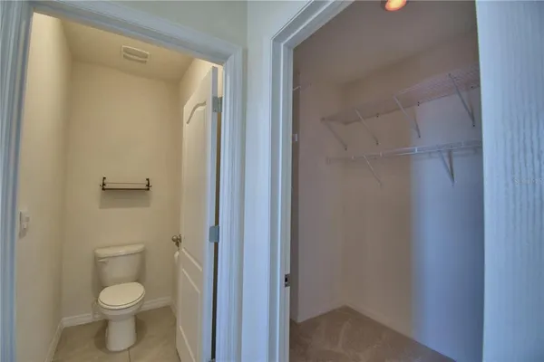 a bathroom with a granite countertop toilet and a sink