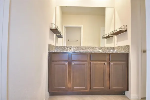 a bathroom with a granite countertop sink and a mirror