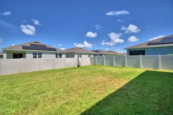 a backyard of a house with table and chairs