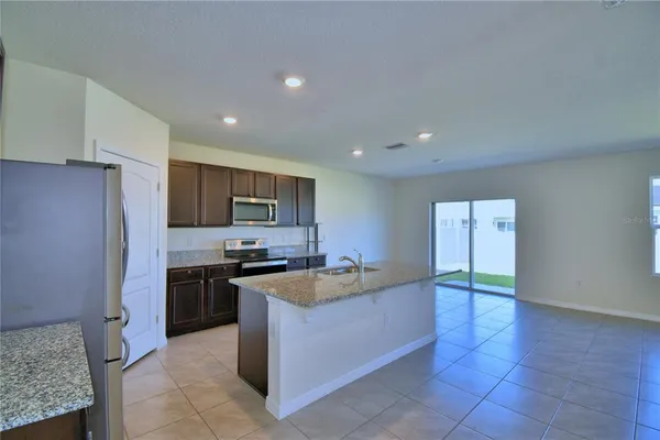 a kitchen with stainless steel appliances granite countertop a refrigerator and a stove