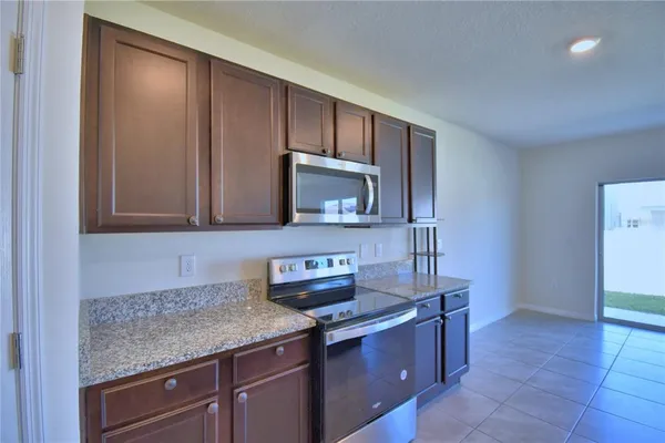 a kitchen with stainless steel appliances granite countertop a sink stove and cabinets