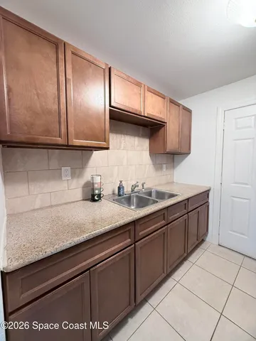 a bathroom with a granite countertop sink a toilet a mirror and bathtub