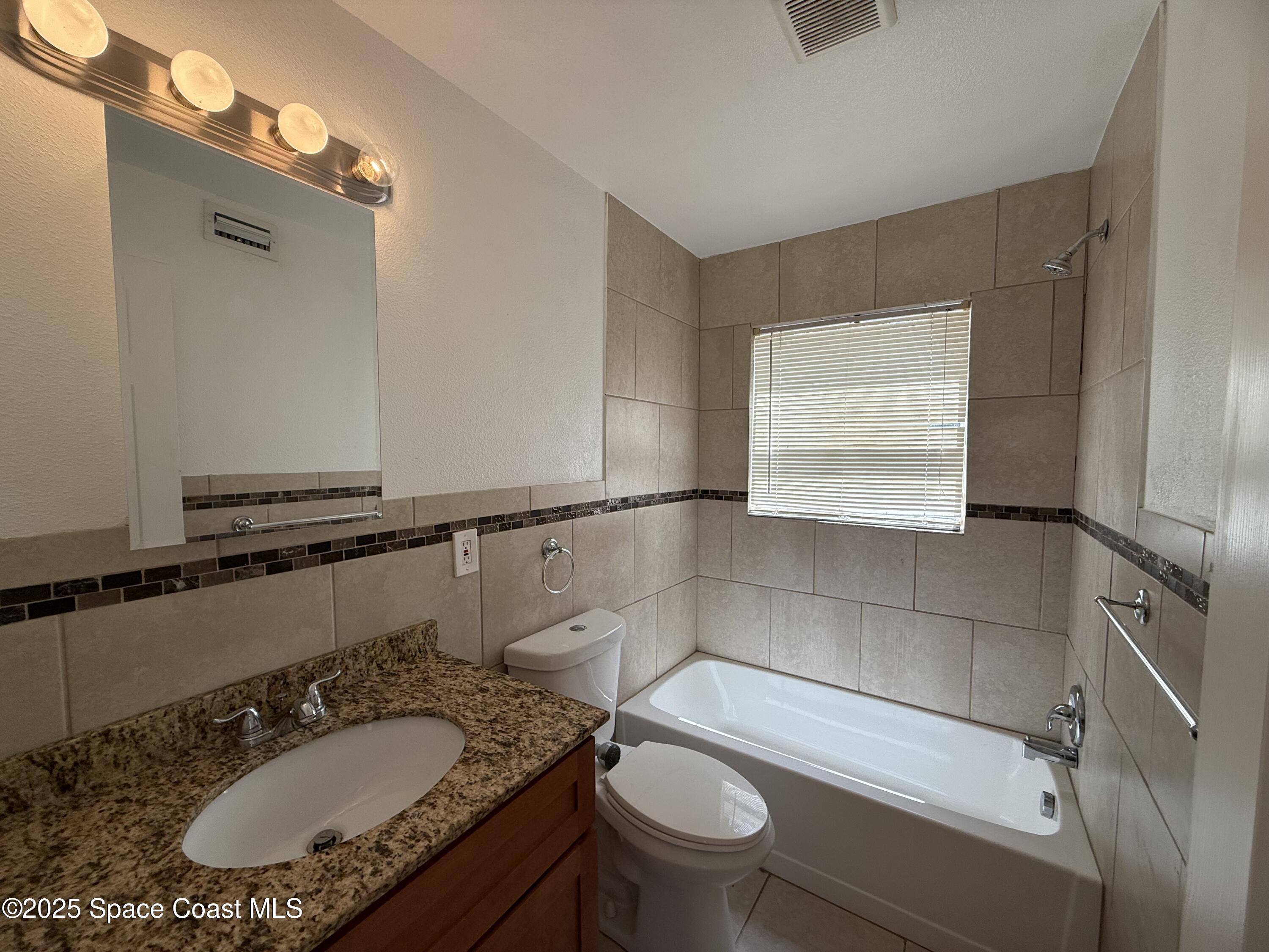 1440 Parkway Drive, Unit 8A Melbourne, FL 32935 - Photo 8 of 21 a bathroom with a sink a toilet and a mirror