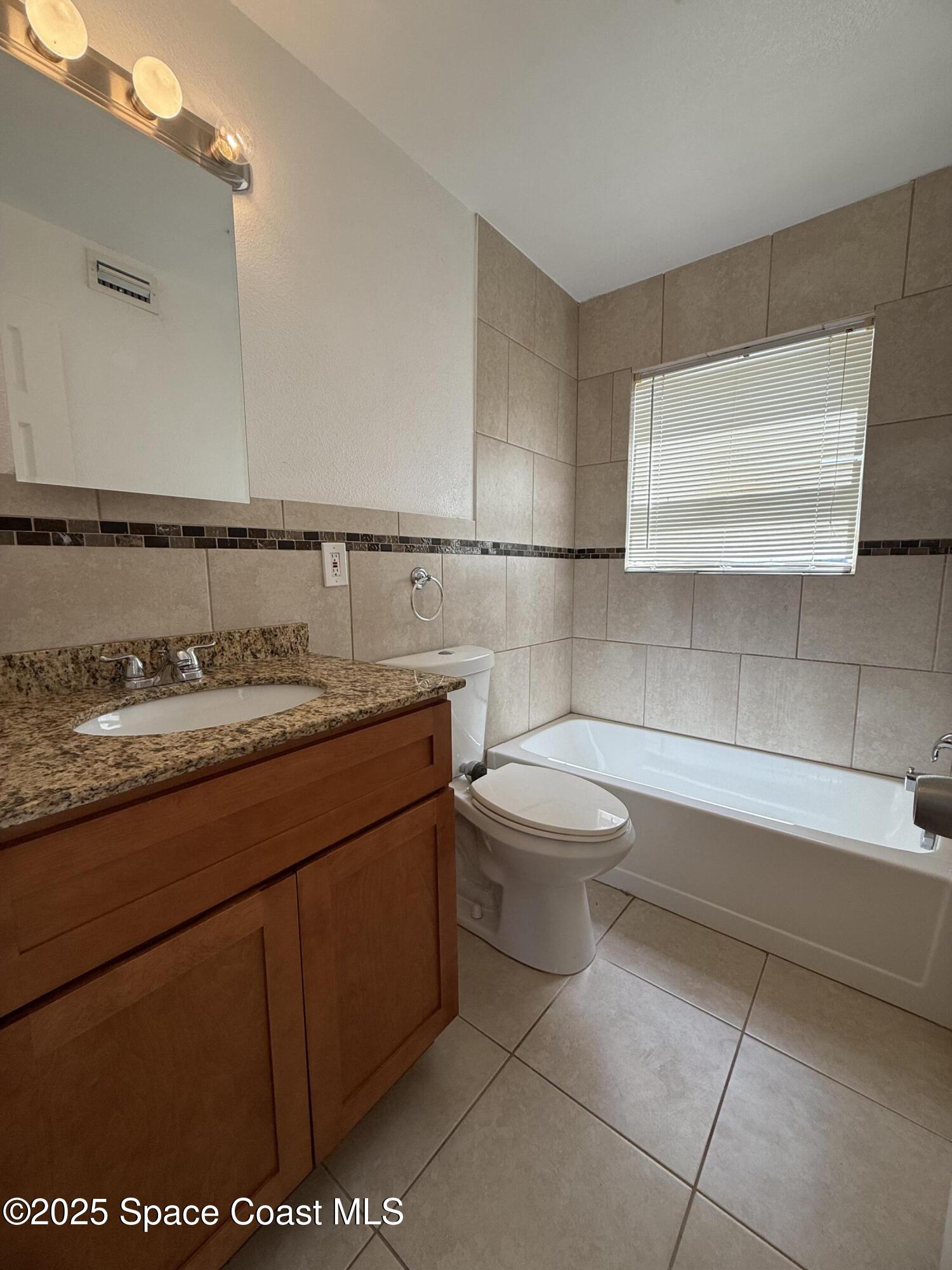 1440 Parkway Drive, Unit 8A Melbourne, FL 32935 - Photo 9 of 21 a bathroom with a sink a toilet and mirror