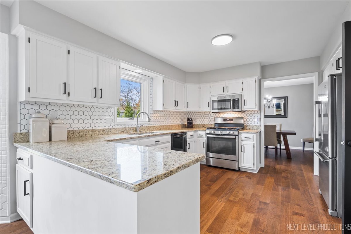 602 Highbury Lane Geneva, IL 60134 - Photo 12 of 28 a kitchen with granite countertop a sink cabinets and stainless steel appliances