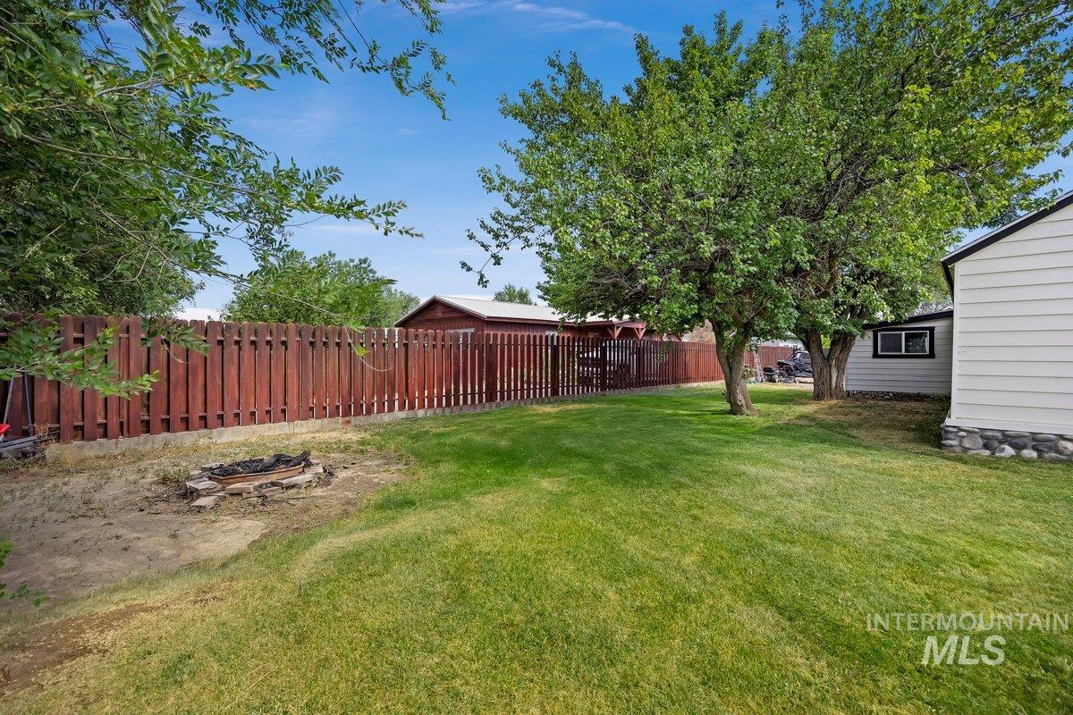 418 South Date Street Shoshone, ID 83352 - Photo 24 of 36 Expansive backyard featuring a manicured lawn, established trees, and a full-height privacy fence