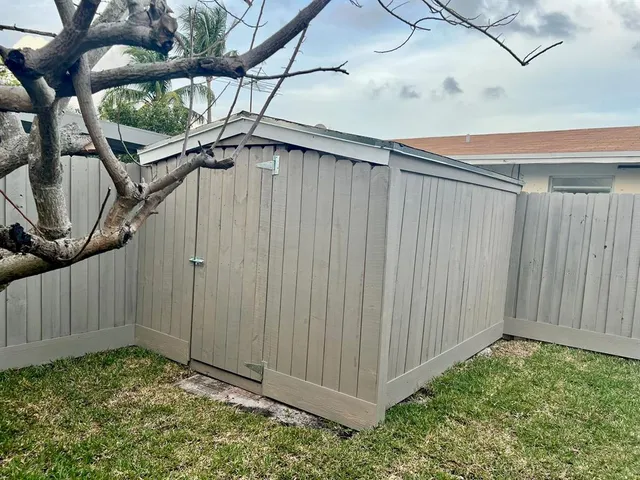 a view of a yard with wooden fence