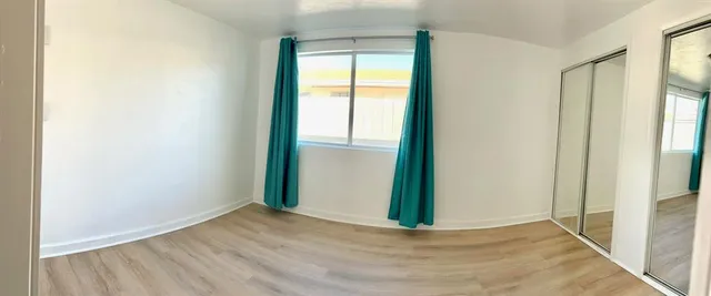 an empty room with closet and a bathroom