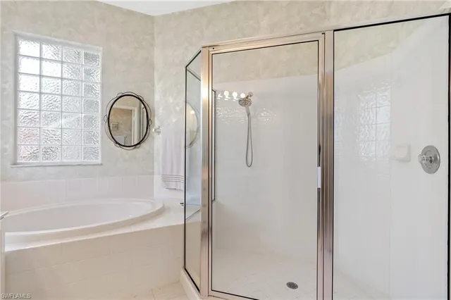 a bathroom with a shower and a bath tub