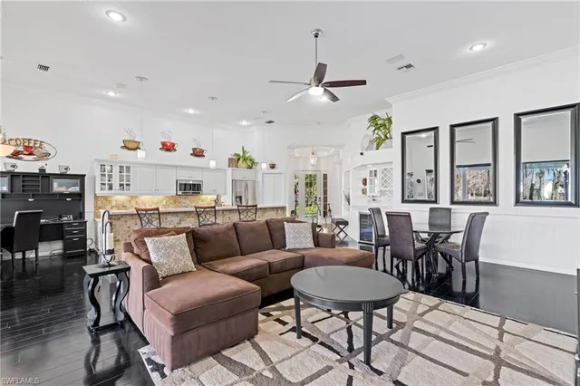 a living room with furniture kitchen view and a chandelier