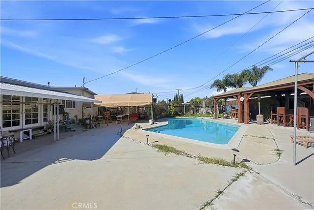 a view of a patio with a table and chairs under an umbrella