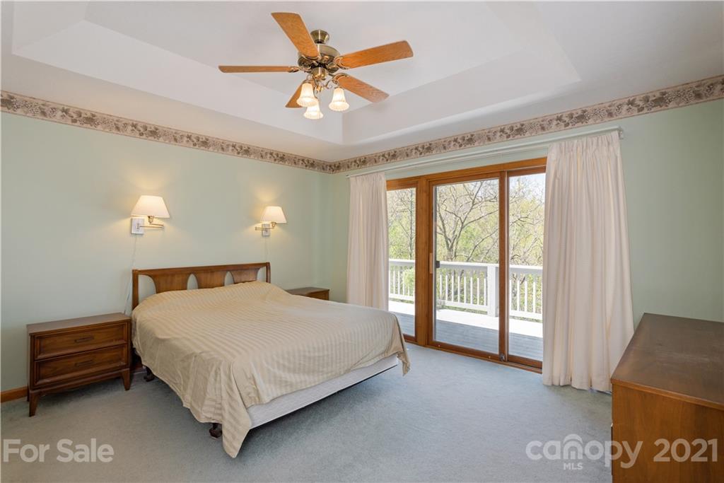5561 Spring Road Hendersonville, NC 28739 - Photo 18 of 30 a bedroom with a bed and a chandelier