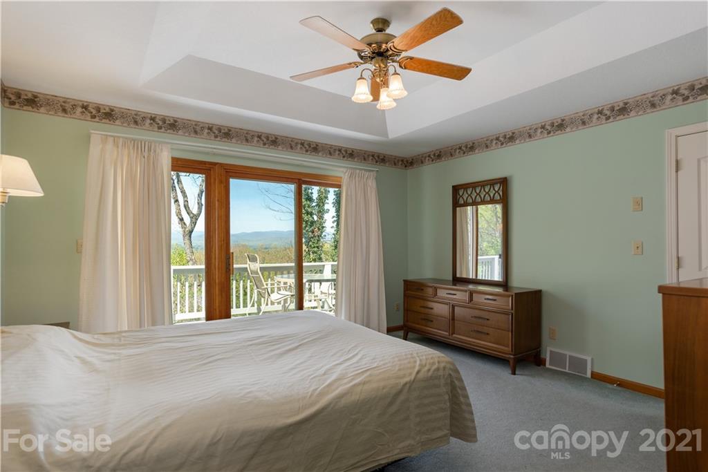 5561 Spring Road Hendersonville, NC 28739 - Photo 19 of 30 a bedroom with a bed and a chandelier