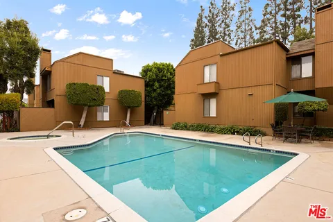 a view of a house with pool and a yard